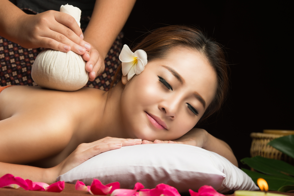 Massage mit warmen Kräuterstempeln